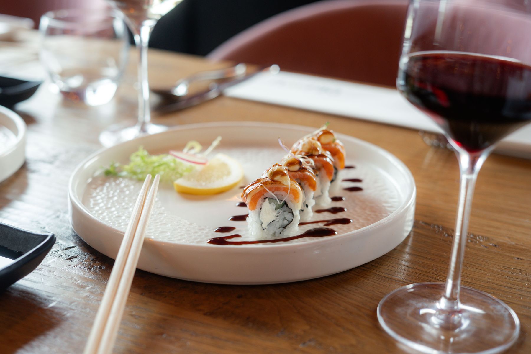 Bord met sushi en een glas rode wijn