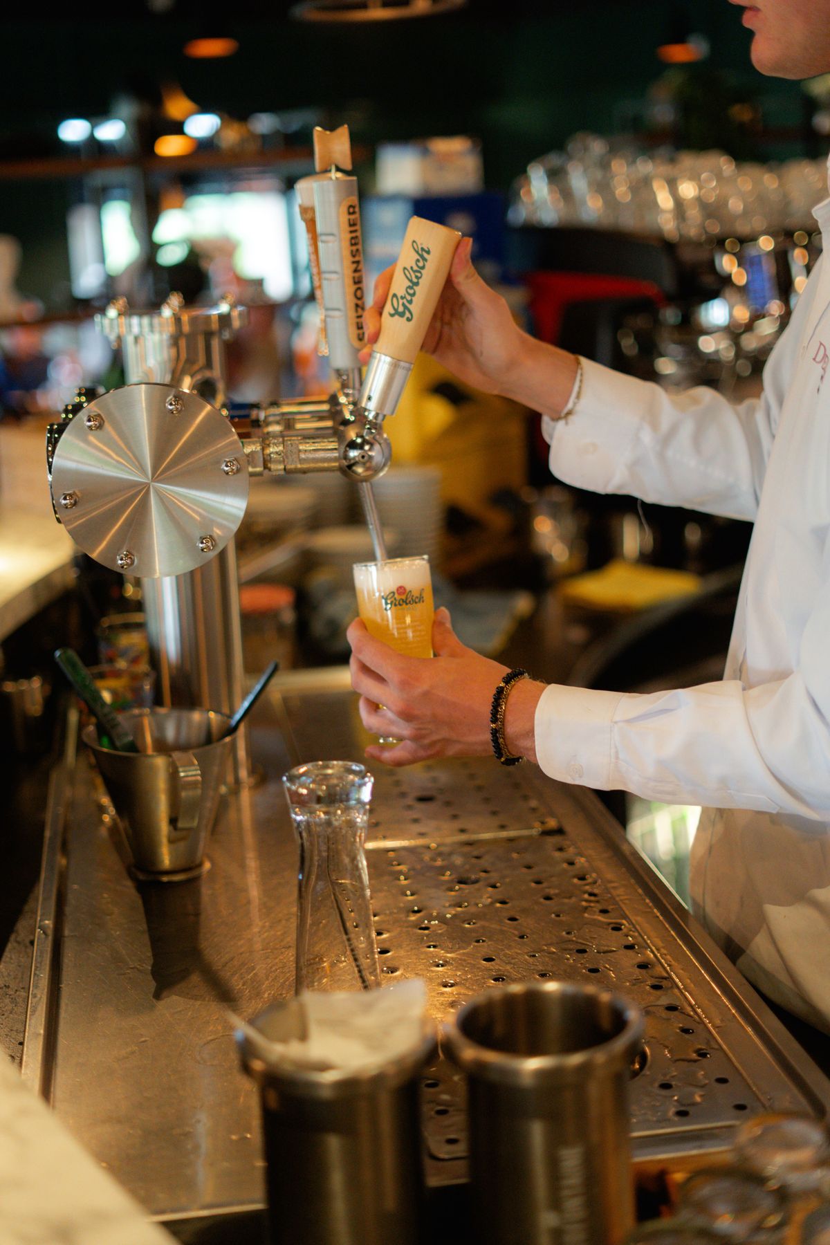 Medewerker tapt een biertje aan de bar