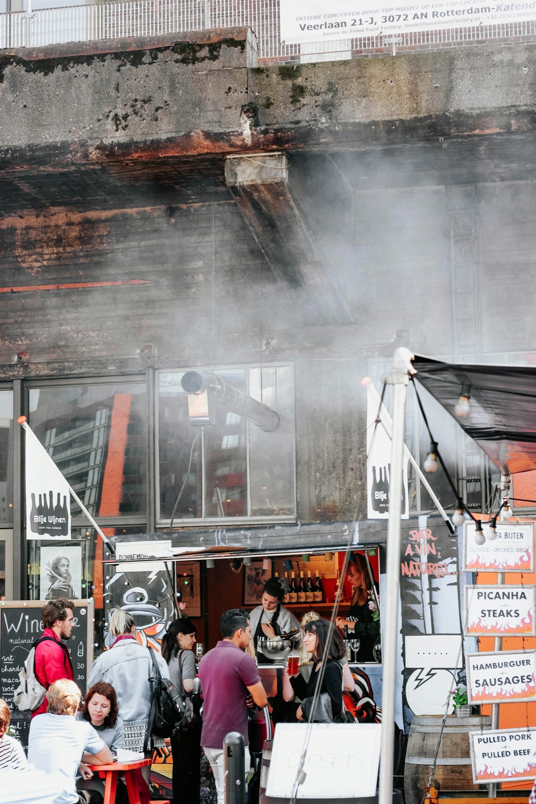 Kraam met een rokende grill op een foodmarkt