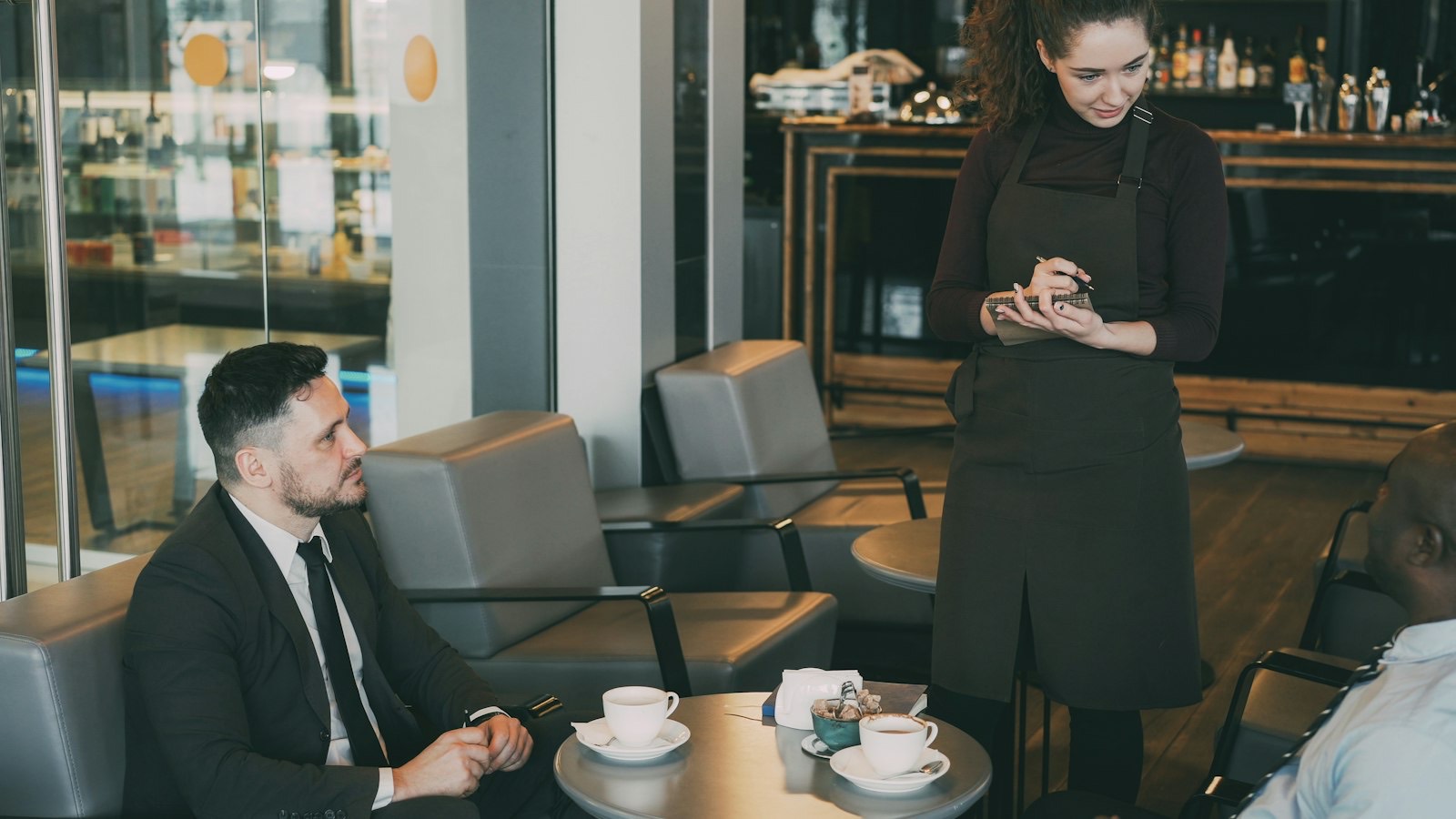 Serveerster neemt de bestelling op bij twee gasten in een café