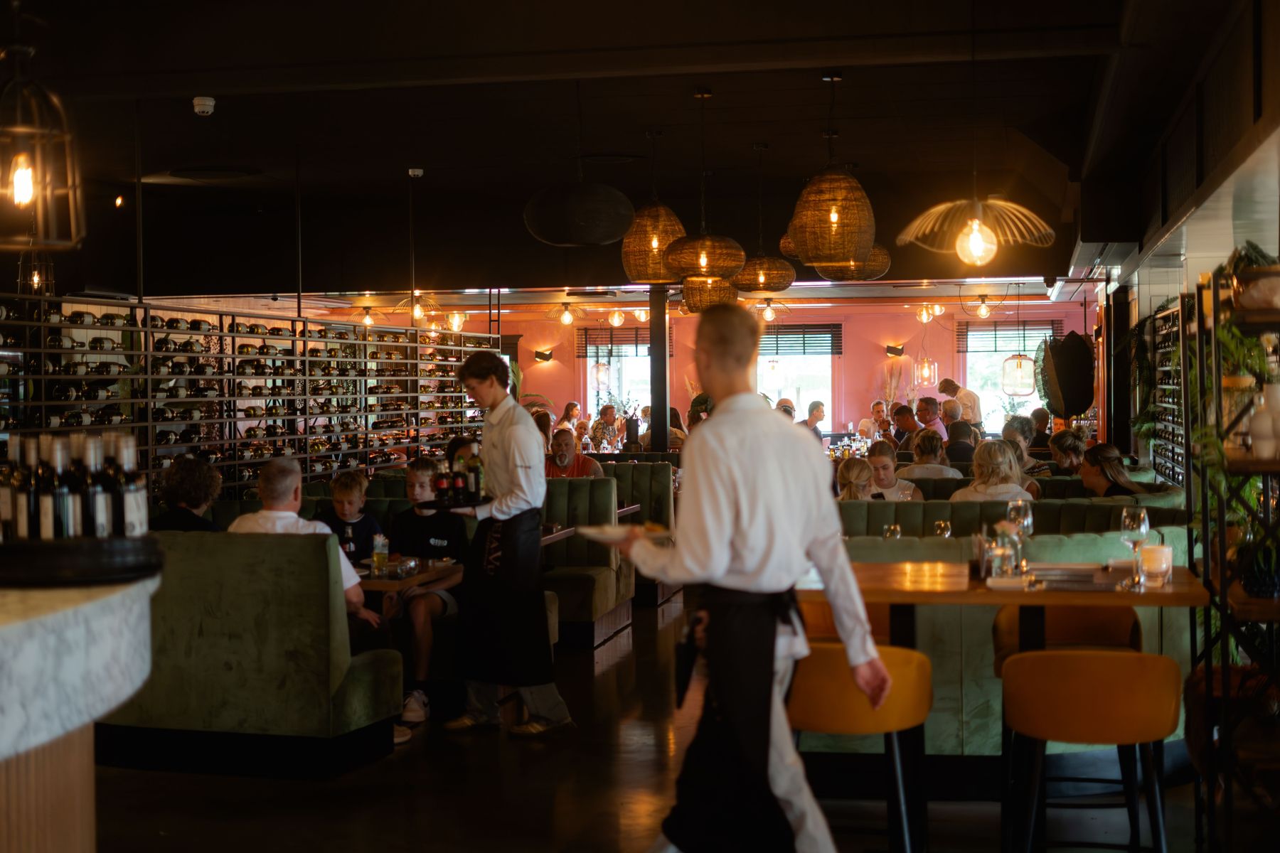 Bediening loopt door een volle restaurantzaal