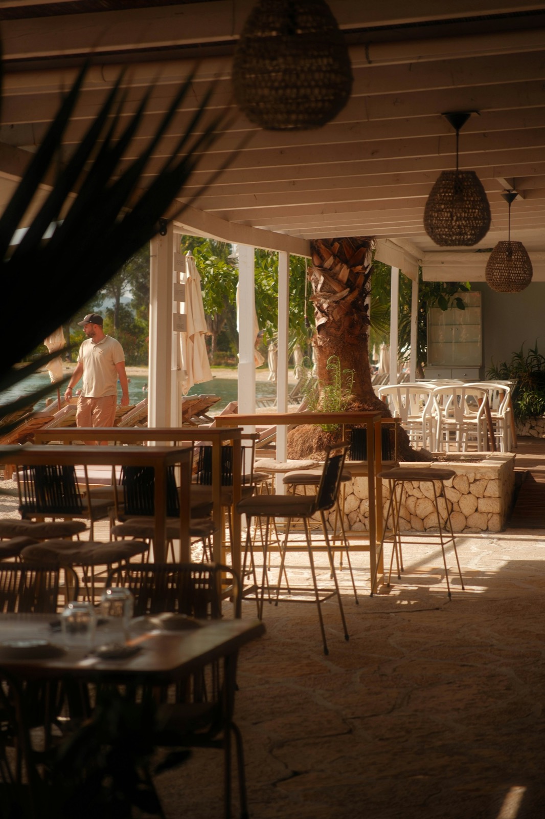 Zonnig terras van een restaurant met gevlochten lampen
