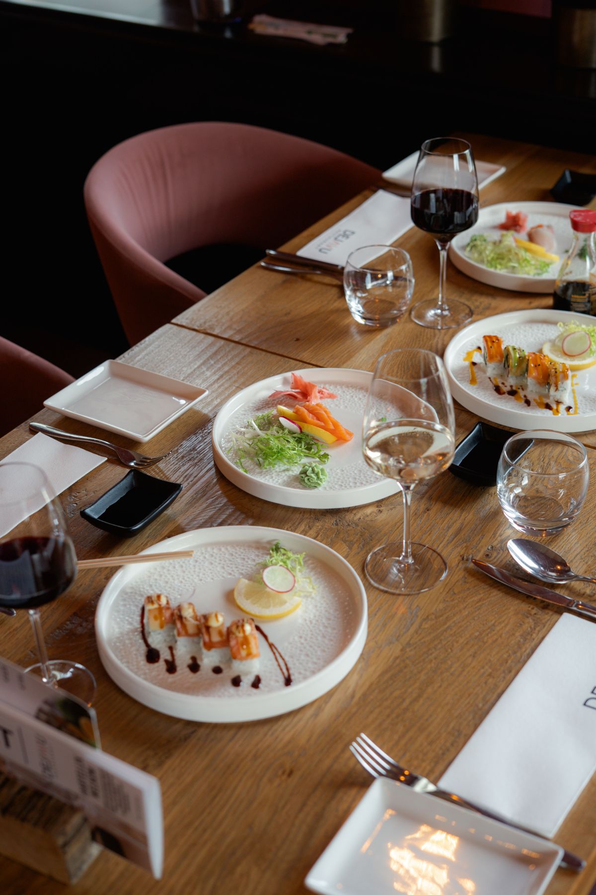 Tafel met sushi, wijn en gedekte borden